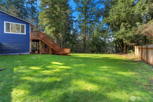 a view of a backyard with wooden fence and a bench