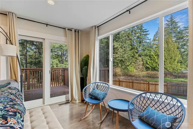 a living room with furniture kitchen view and a large window