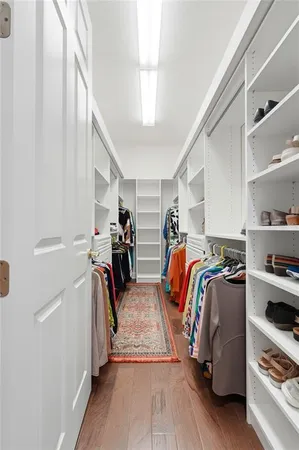 a view of walk in closet with clothes and shoes
