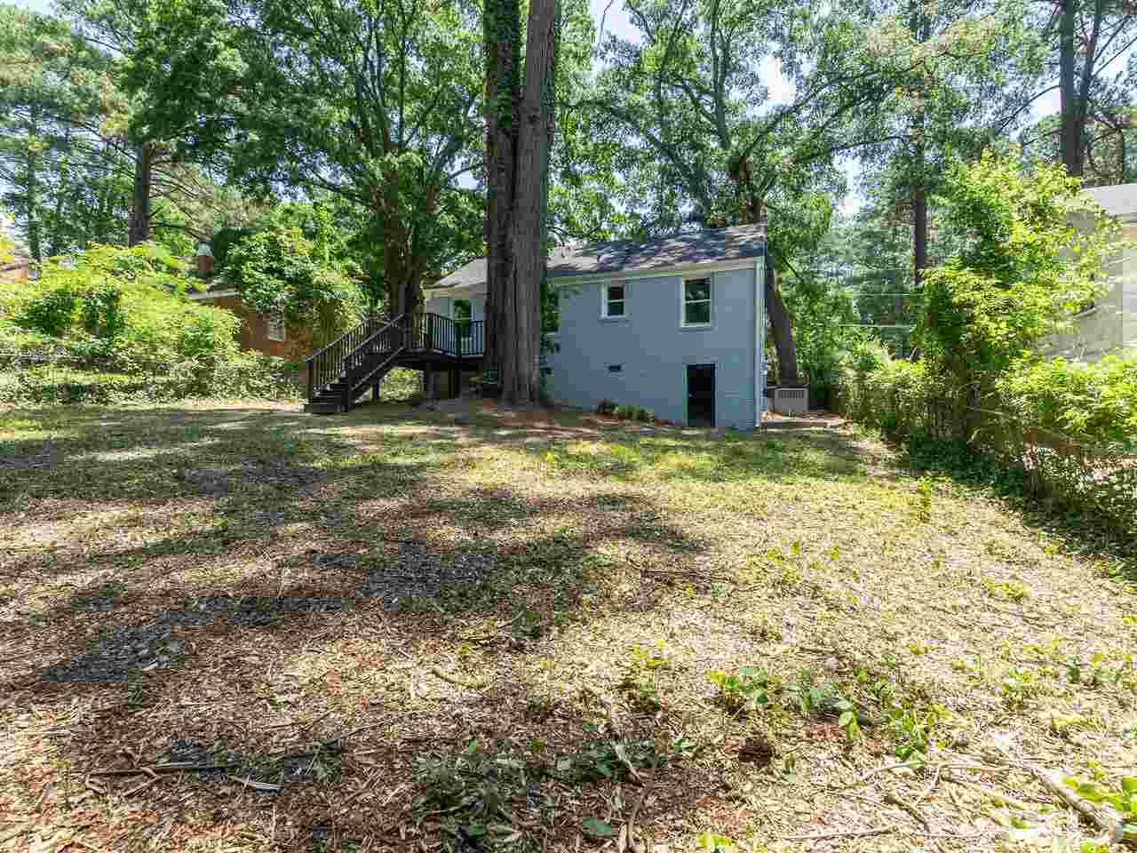 332 Angier Avenue Raleigh, NC 27610 - Photo 4 of 30 a view of a backyard with large tree and wooden fence