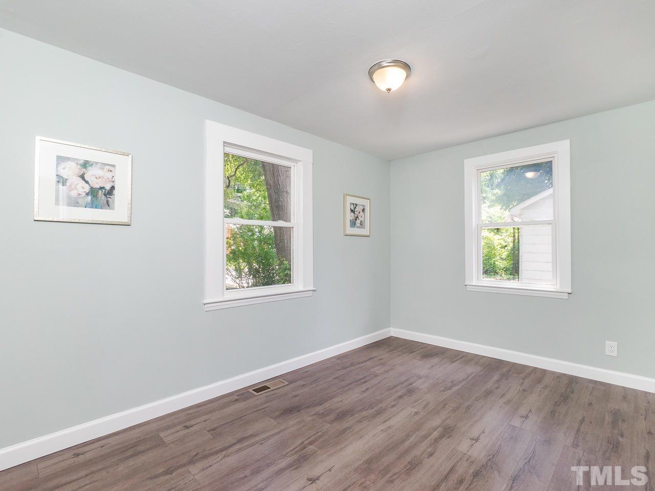 332 Angier Avenue Raleigh, NC 27610 - Photo 8 of 30 a view of an empty room with wooden floor and a window