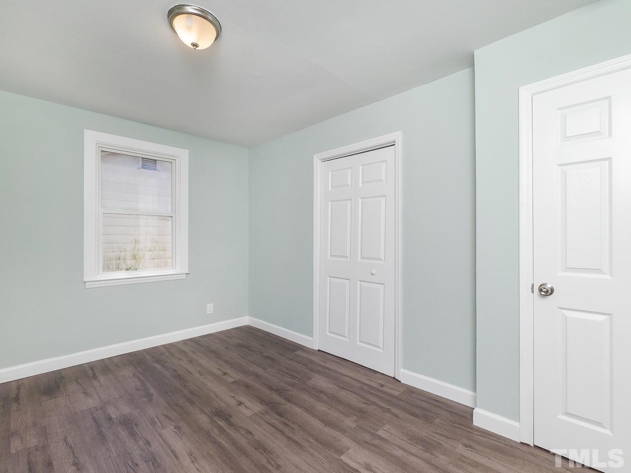 332 Angier Avenue Raleigh, NC 27610 - Photo 9 of 30 an empty room with wooden floor and windows