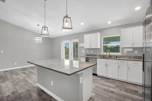 a kitchen with granite countertop a sink a center island a counter space and a window