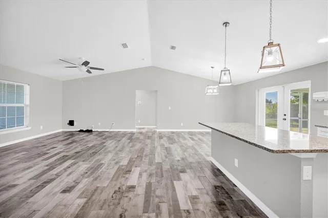 a view of a room with wooden floor and ceiling fan