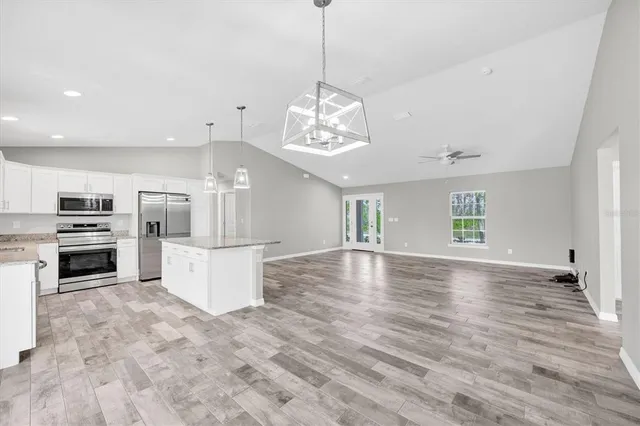 a view of a kitchen with a sink microwave and cabinets