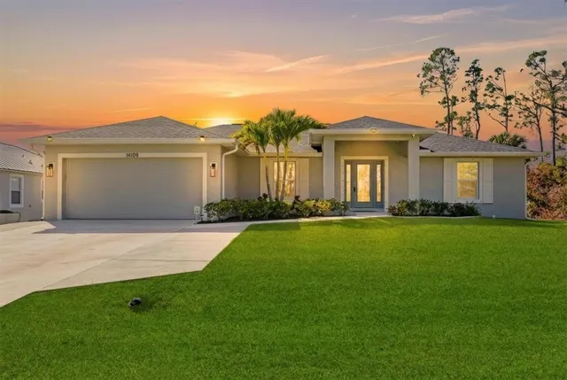 a front view of a house with a garden and yard