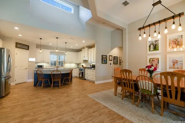 a living room with furniture a flat screen tv and kitchen view