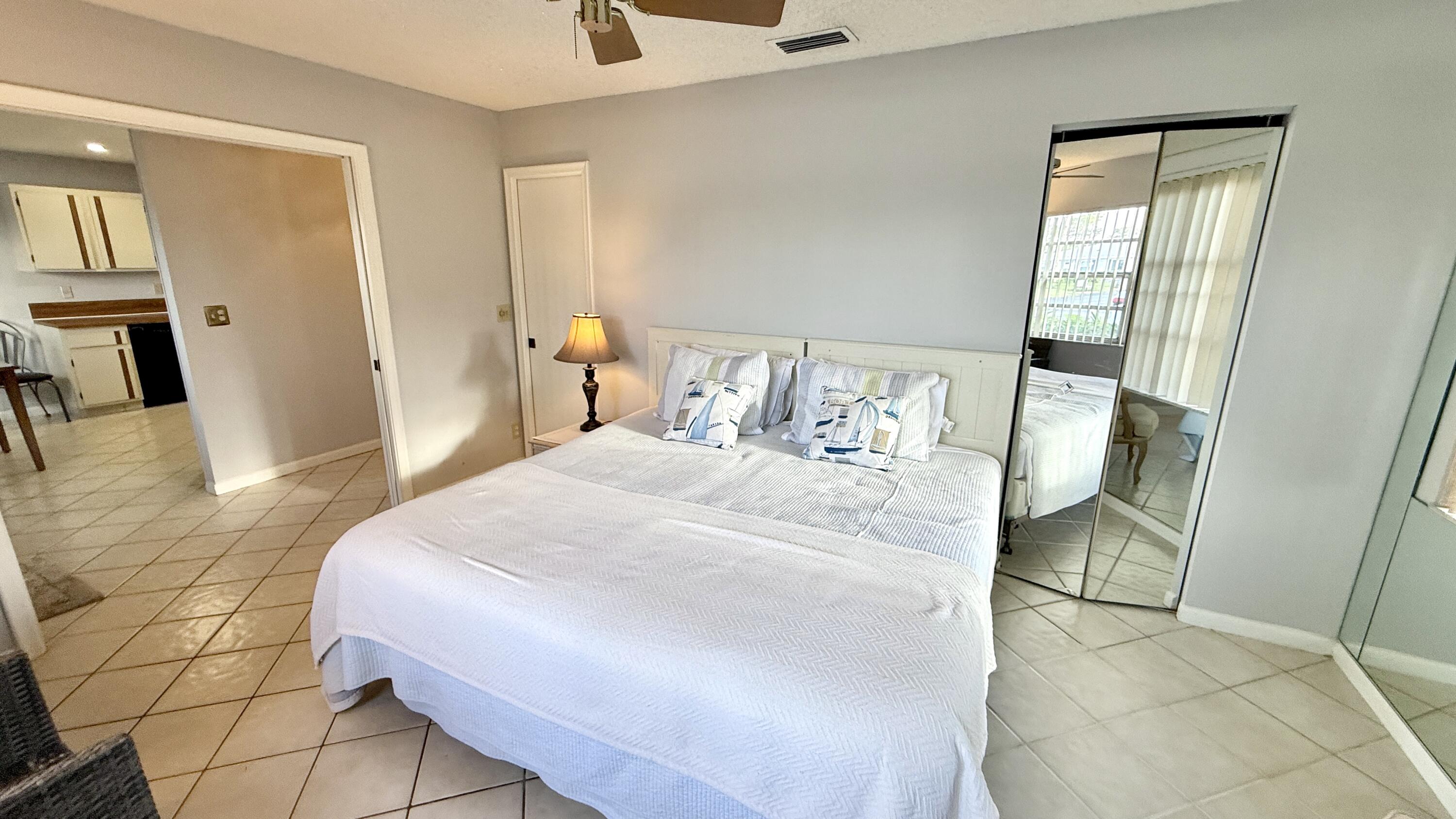 5242 Privet Place Delray Beach, FL 33484 - Photo 19 of 50 a bedroom with a bed and a mirror