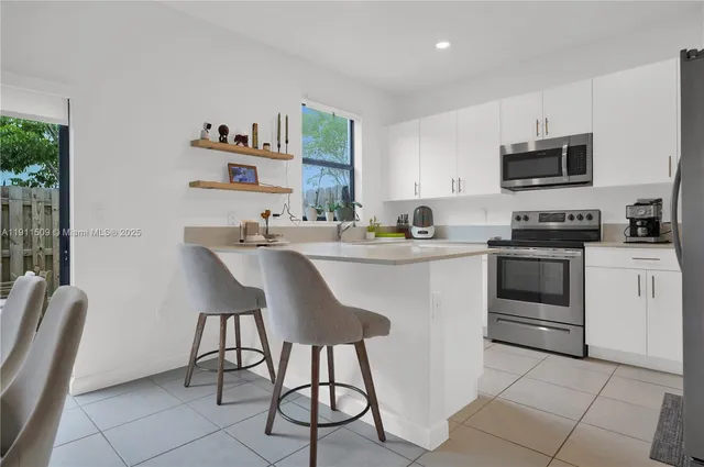 a kitchen with stainless steel appliances a stove a sink dishwasher and a refrigerator