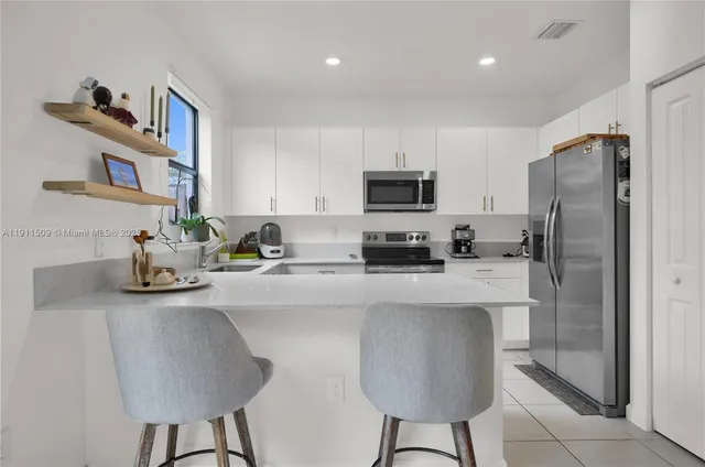 a kitchen with stainless steel appliances a sink counter space and a refrigerator