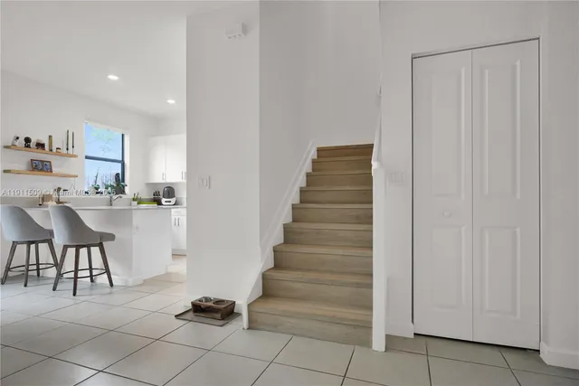a kitchen with white cabinets and chair