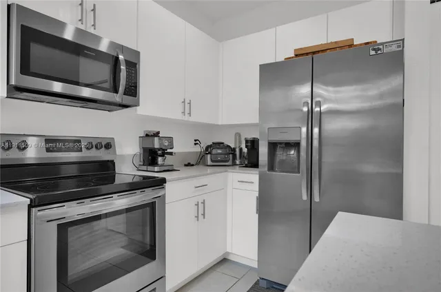 a kitchen with cabinets stainless steel appliances and a wooden floor