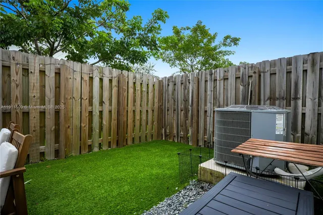 a lawn chairs sitting in a backyard with wooden fence