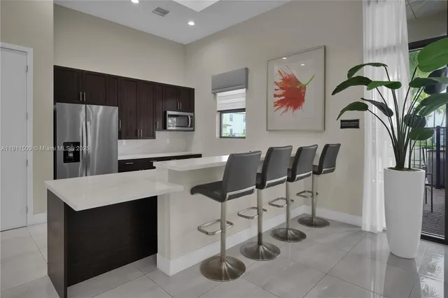 a kitchen with stainless steel appliances a stove a refrigerator a sink cabinets and dining table