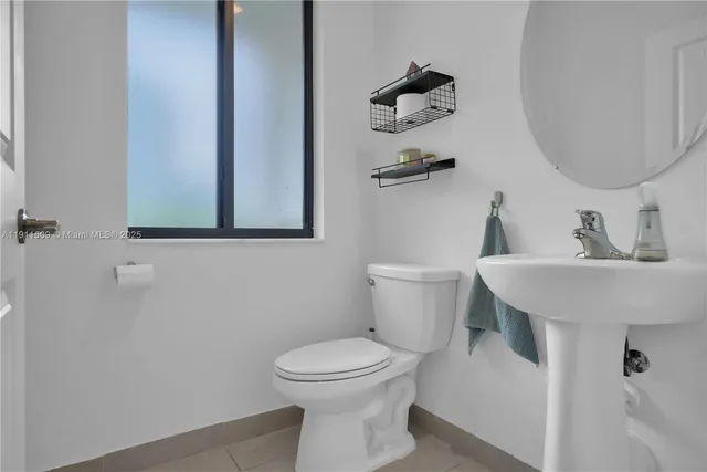 a bathroom with a toilet a sink and mirror