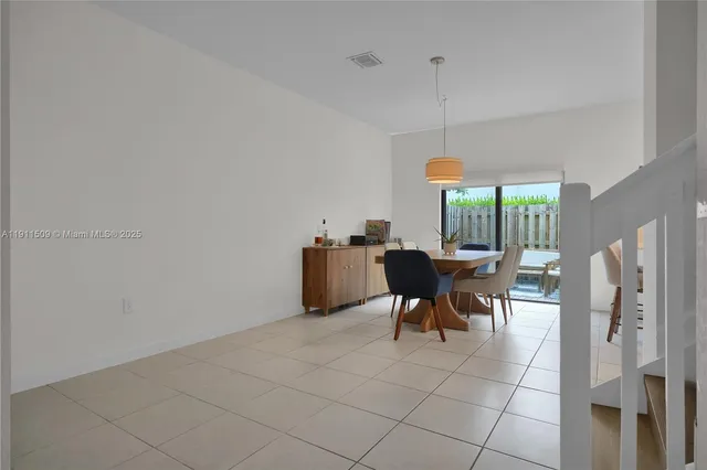 a dining room with furniture and a floor to ceiling window
