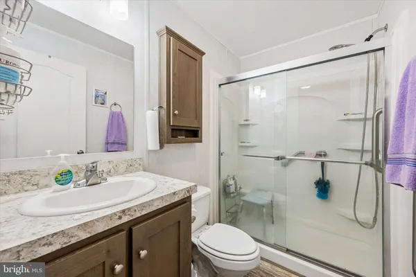 a bathroom with a granite countertop sink toilet and shower