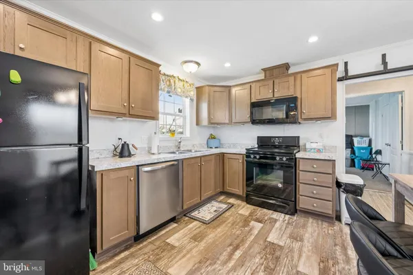 a kitchen with stainless steel appliances a stove a sink a microwave a refrigerator and cabinets
