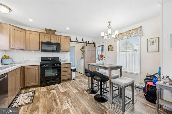 a kitchen with granite countertop a stove top oven a sink dishwasher and a refrigerator with wooden floor