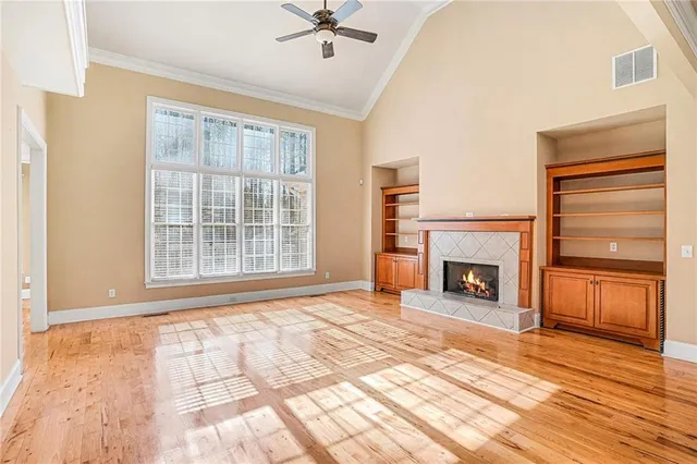 a view of an empty room with a fireplace and a window