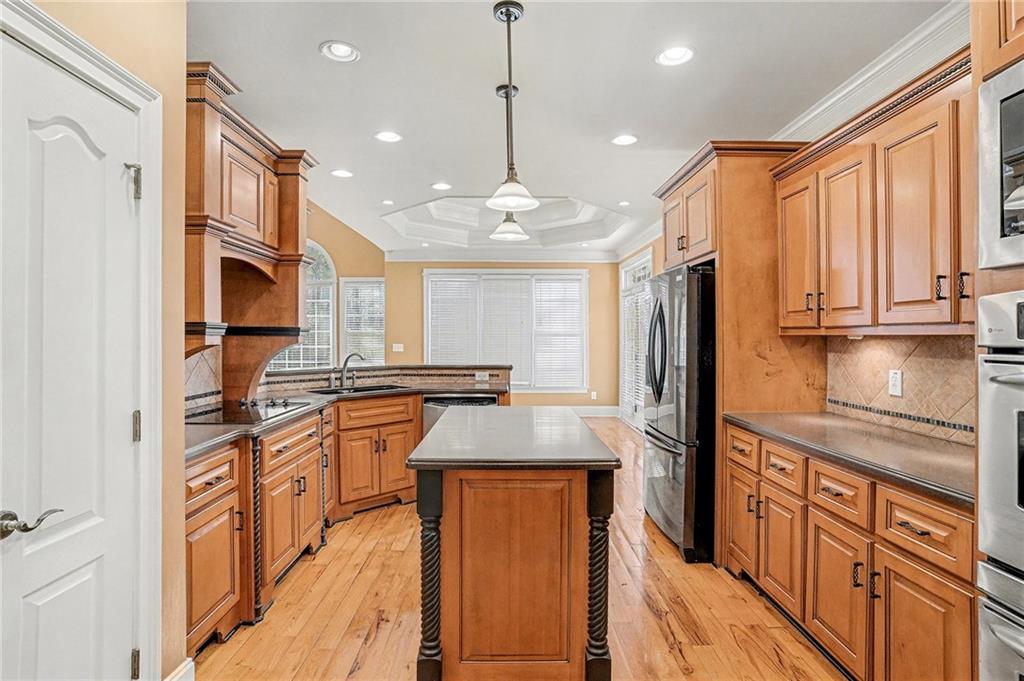 390 Glengarry Chase Covington, GA 30014 - Photo 8 of 21 a kitchen with stainless steel appliances granite countertop a refrigerator a oven a sink and dishwasher with wooden floor