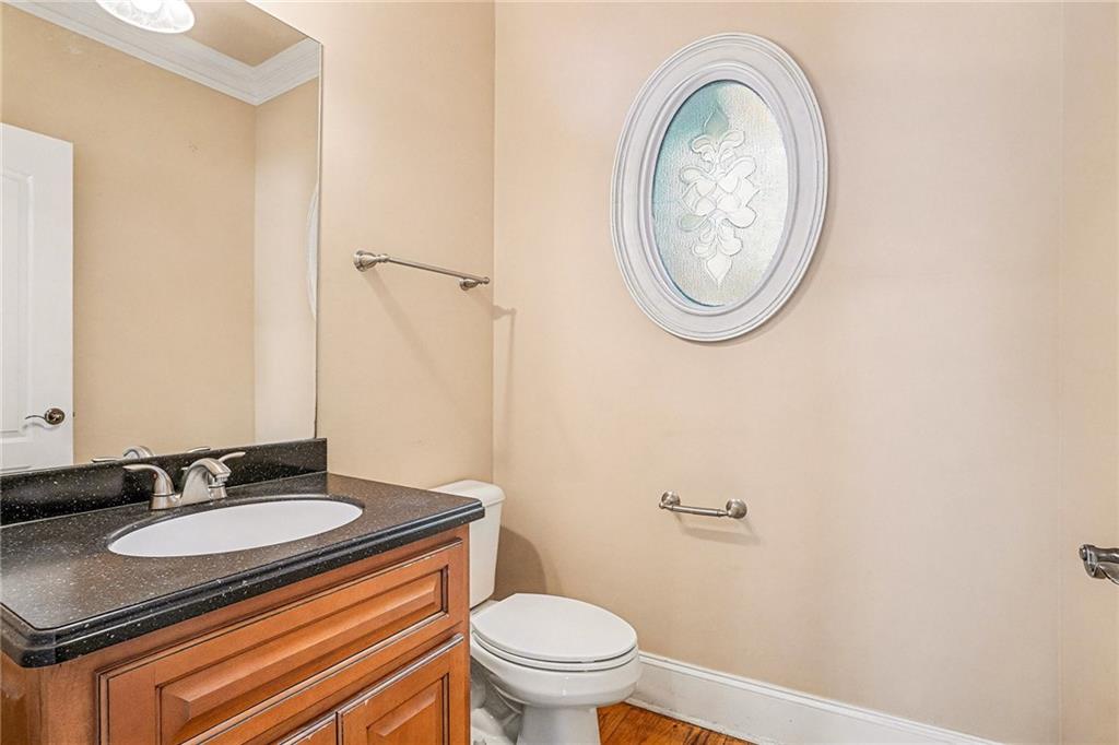 390 Glengarry Chase Covington, GA 30014 - Photo 9 of 21 a bathroom with a granite countertop toilet a sink and a mirror