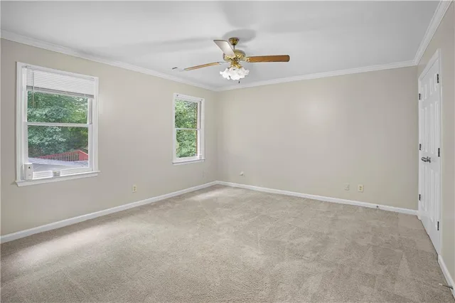 a bathroom with a granite countertop sink a toilet and a window