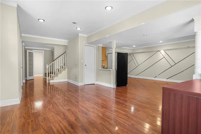 a view of an empty room with chandelier fan