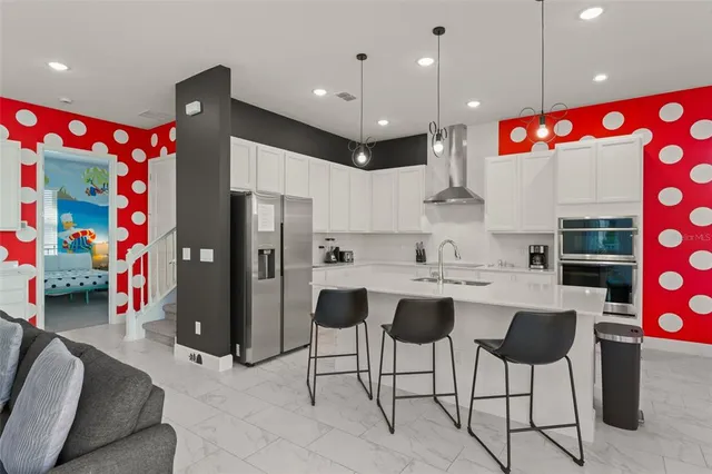 a kitchen with stainless steel appliances kitchen island granite countertop a refrigerator and a sink