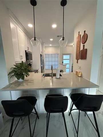 a kitchen with a dining table chairs and white cabinets
