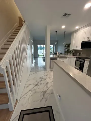 a kitchen with stainless steel appliances kitchen island granite countertop a refrigerator a stove and a sink with wooden floor