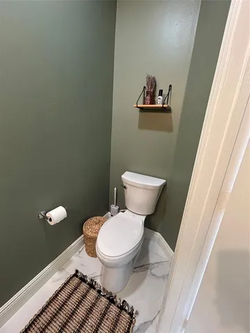 a white toilet sitting next to a small bathroom