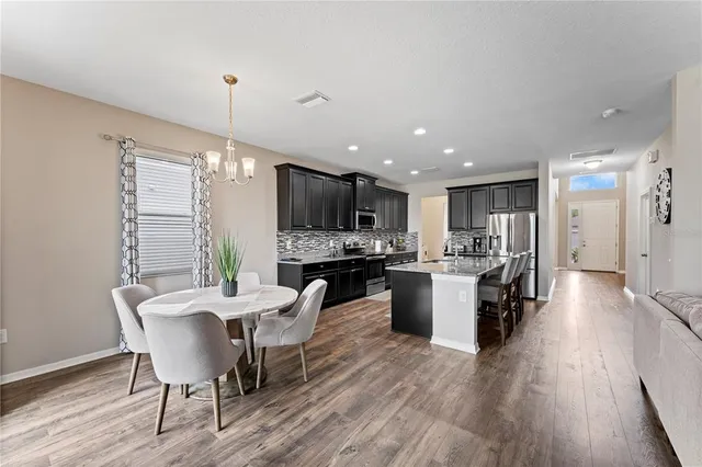 a living room with furniture kitchen view and a large window