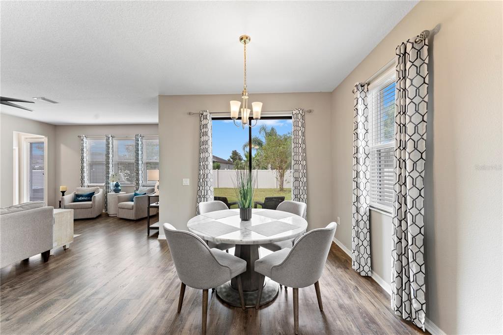 19065 Malinche Loop Spring Hill, FL 34610 - Photo 24 of 72 a view of a dining room with furniture wooden floor and a chandelier