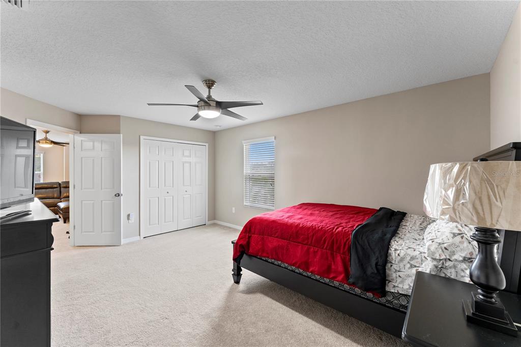 19065 Malinche Loop Spring Hill, FL 34610 - Photo 39 of 72 a bedroom with a bed and a ceiling fan