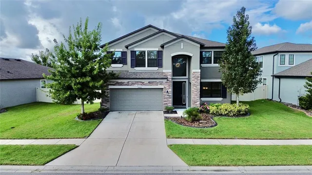 a front view of a house with a yard and garage