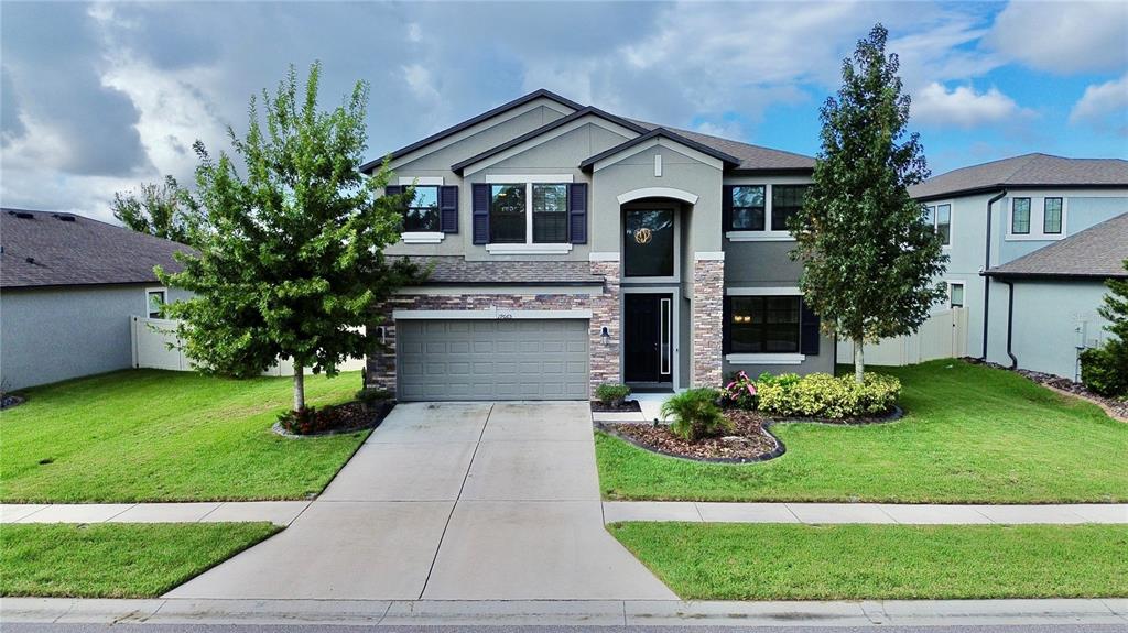 19065 Malinche Loop Spring Hill, FL 34610 - Photo 4 of 72 a front view of a house with a yard and garage
