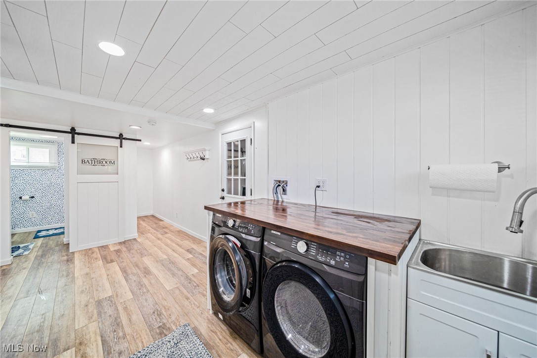 2716 Russell Road Ashtabula, OH 44004 - Photo 18 of 43 Laundry room with washing machine and dryer, a barn door, and light wood finished floors