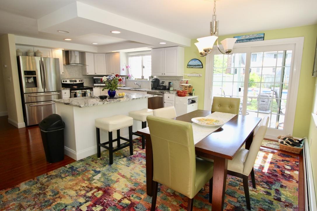 10 Lan Road Sandwich, MA 02563 - Photo 12 of 35 a kitchen with stainless steel appliances granite countertop a dining table chairs refrigerator and sink