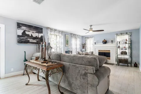 a living room with furniture a fireplace and a window