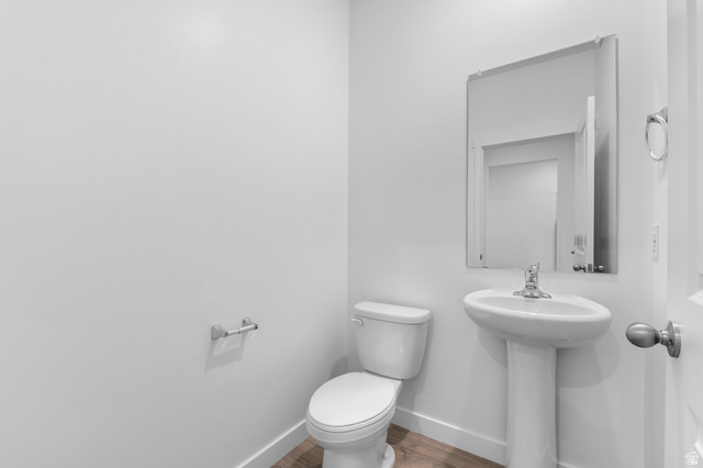 2829 North 710 West, Unit 15 Logan, UT 84321 - Photo 7 of 23 Powder room featuring a pedestal sink, wall-mounted mirror, and wood-finish flooring