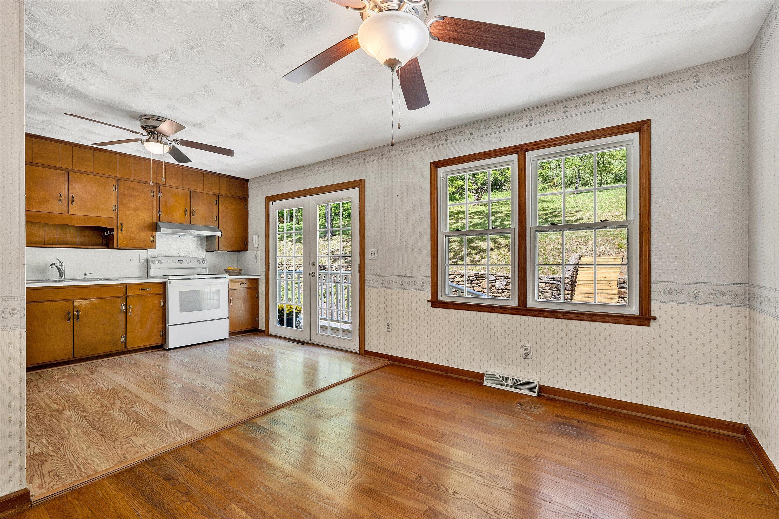 133 Kelsey Way Fincastle, VA 24090 - Photo 16 of 58 a large kitchen with stainless steel appliances granite countertop a stove a sink dishwasher and white cabinets with wooden floor