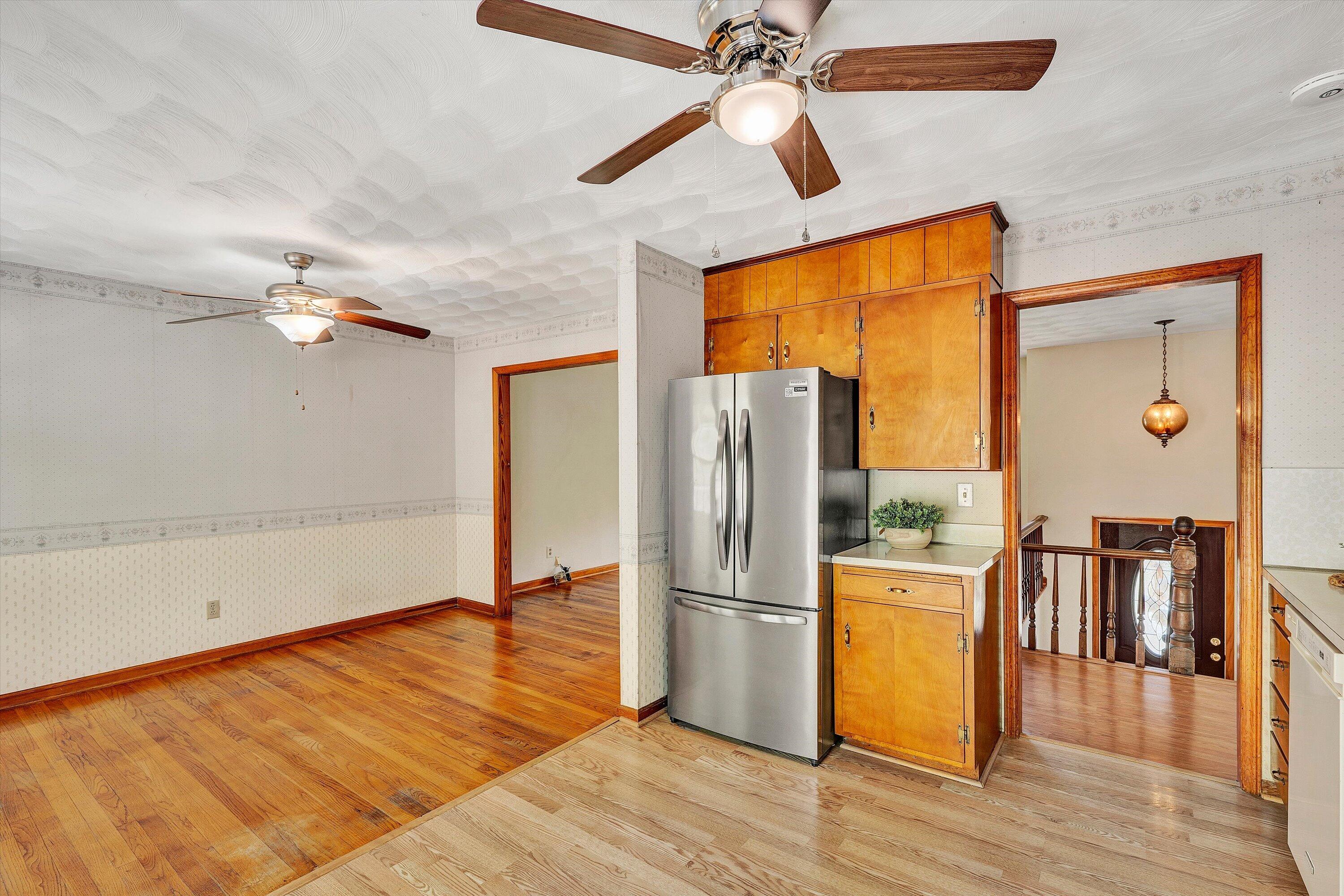 133 Kelsey Way Fincastle, VA 24090 - Photo 19 of 58 a view of a kitchen with a wooden floor a refrigerator a ceiling fan and wooden floor