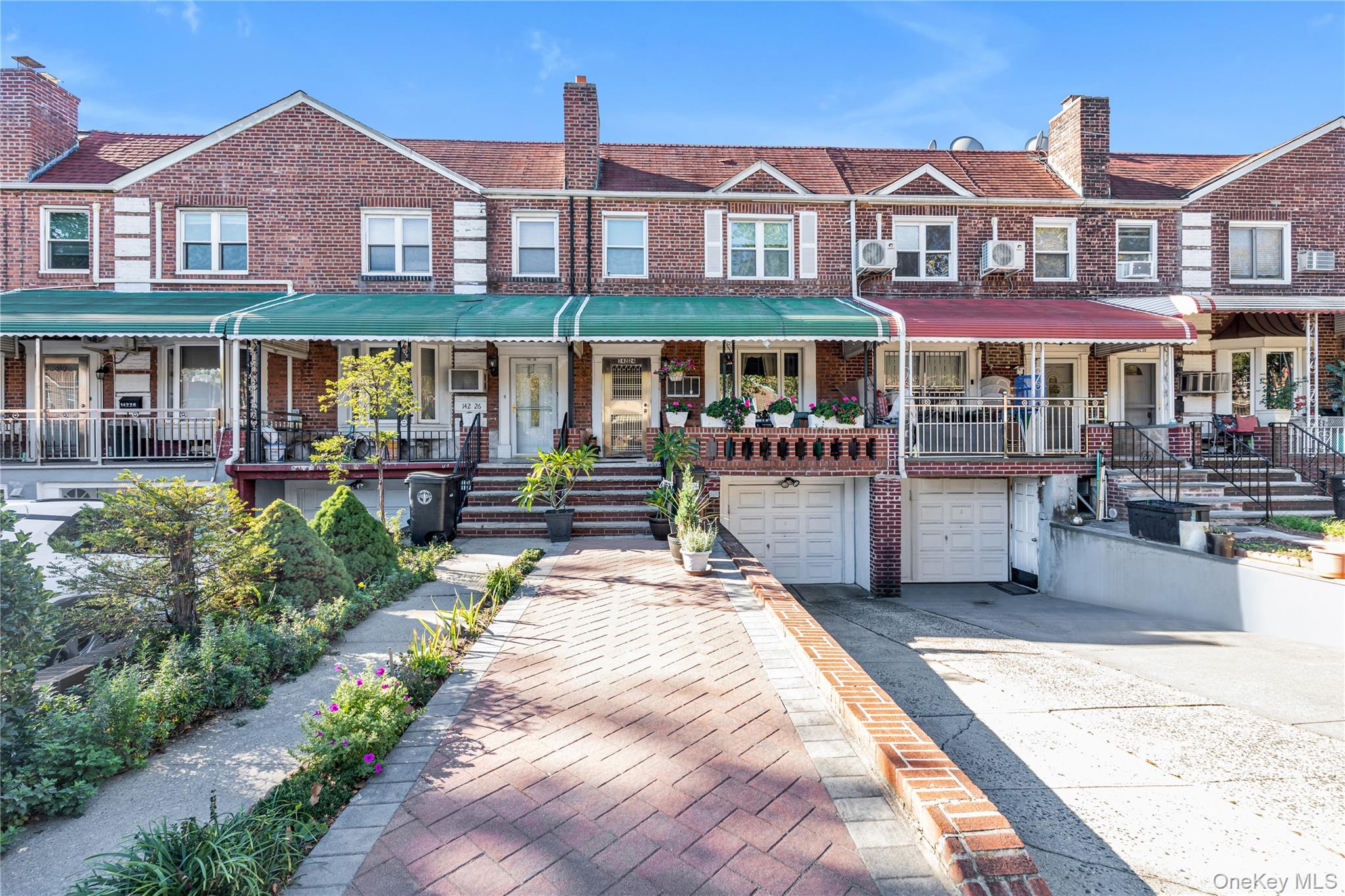 142-24 61st Road Queens, NY 11367 - Photo 1 of 18 View of front of property with a porch, driveway, brick siding, a chimney, and an attached garage