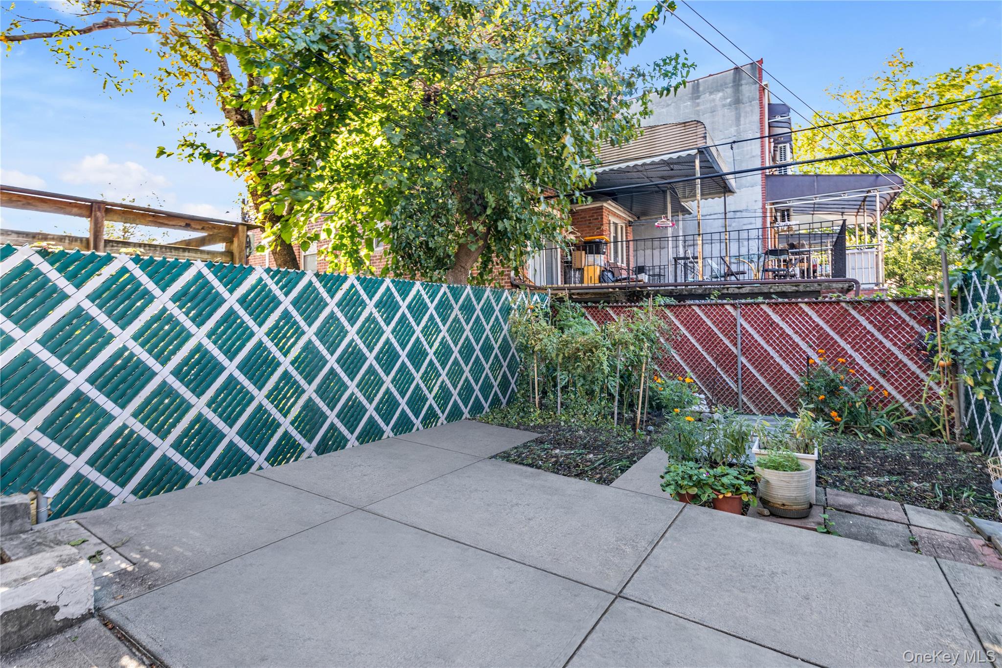 142-24 61st Road Queens, NY 11367 - Photo 16 of 18 Fenced backyard featuring a patio