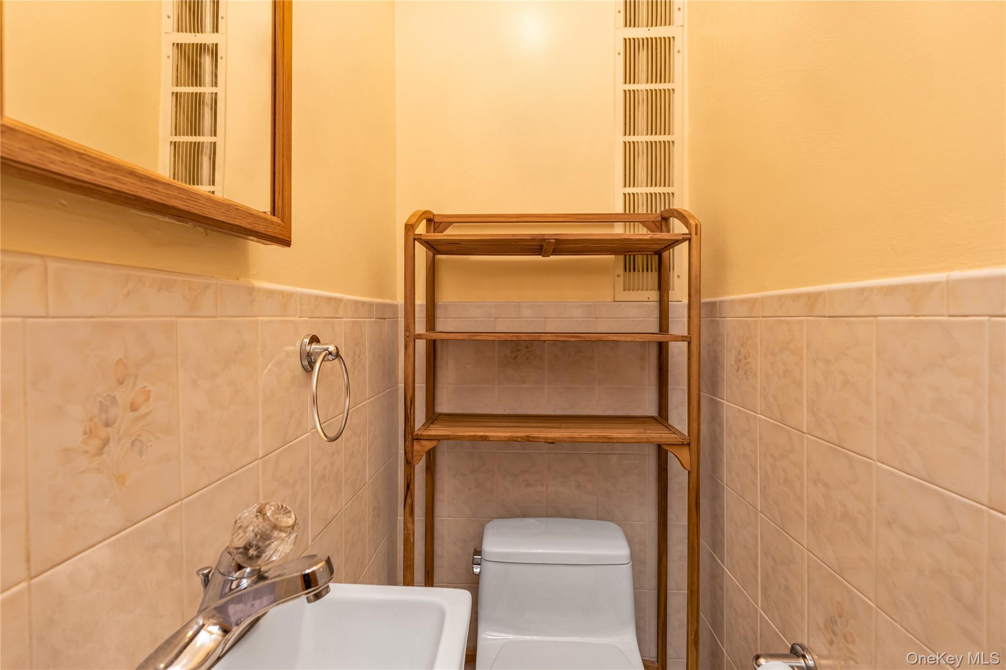 142-24 61st Road Queens, NY 11367 - Photo 8 of 18 Half bath featuring tile walls and wainscoting