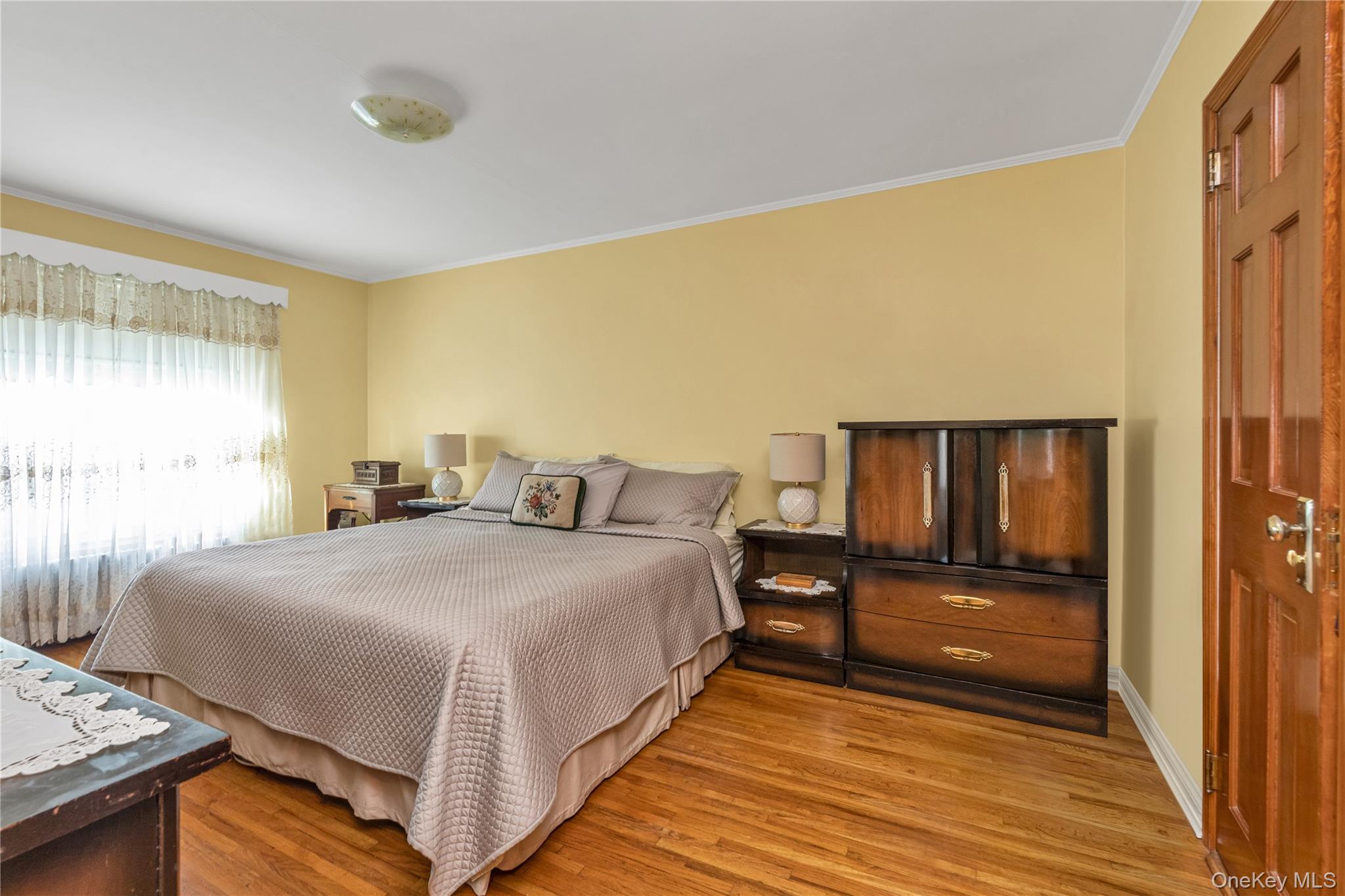 142-24 61st Road Queens, NY 11367 - Photo 9 of 18 Bedroom featuring light wood finished floors and crown molding