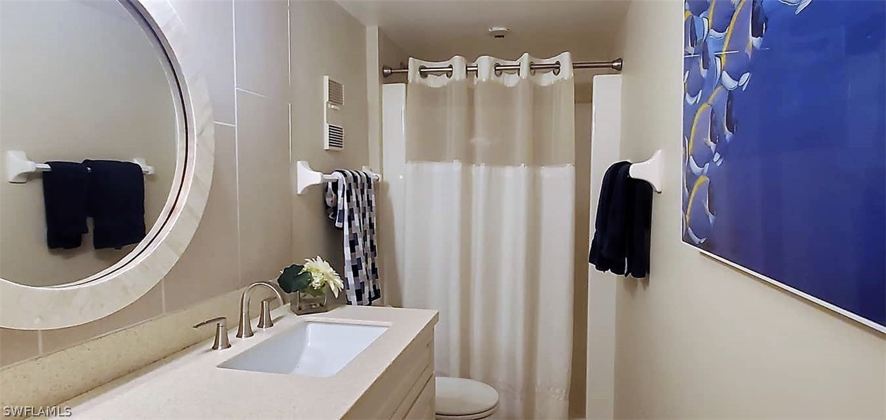 400 Lenell Road, Unit 207 Fort Myers Beach, FL 33931 - Photo 13 of 16 a bathroom with a sink a toilet and mirror