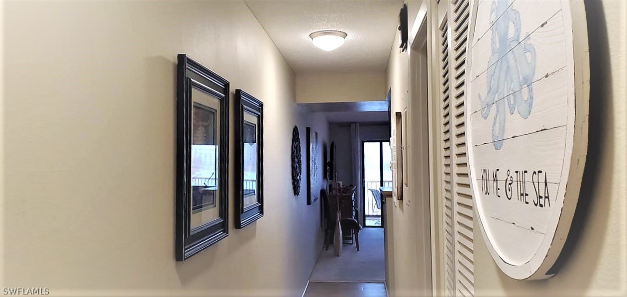400 Lenell Road, Unit 207 Fort Myers Beach, FL 33931 - Photo 14 of 16 a view of a hallway with wooden floor and staircase