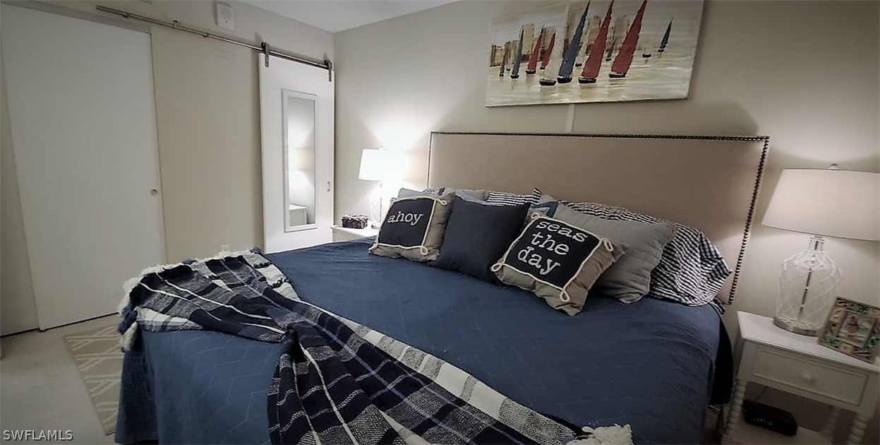 400 Lenell Road, Unit 207 Fort Myers Beach, FL 33931 - Photo 10 of 16 a bed sitting in a bedroom next to a window and a lamp